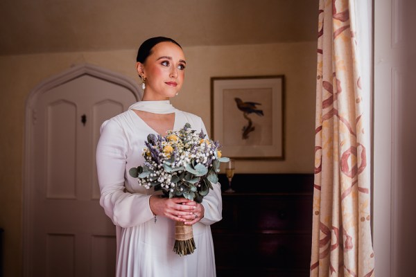 Bride looks out window