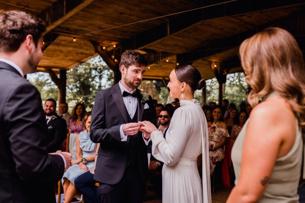 Bride and groom stand at alter together in front of witnesses and celebrant