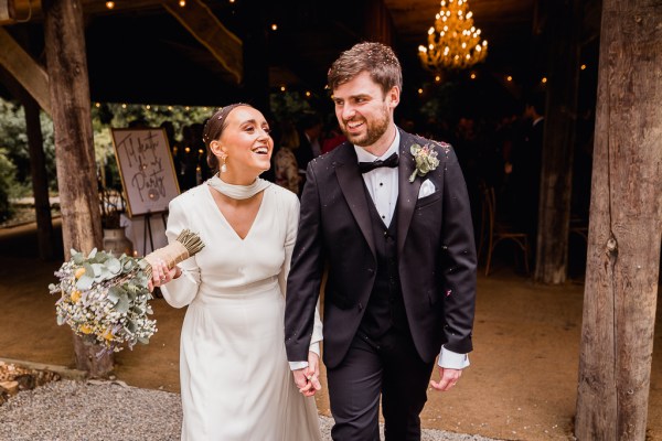 Bride and groom hold hands as they walk outside