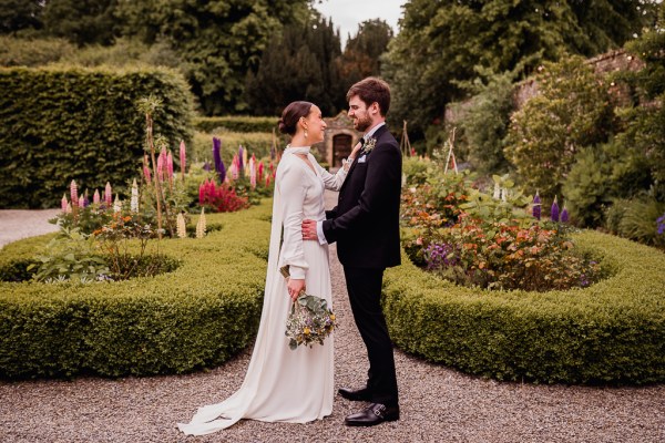 Bride and groom in the garden facing each other