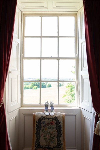 Shot of large window bridal heels shoes laying beside windowsill