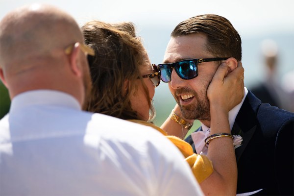 Woman takes grooms face as they chat