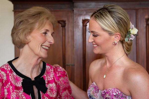 Bride and her mother smile at each other