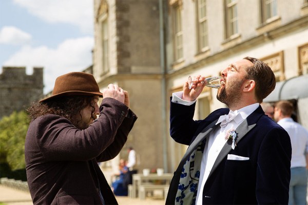 Groom and guest friend drink champagne