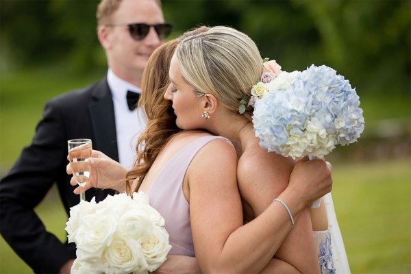 Bride hugs bridesmaid/guest/friend outside