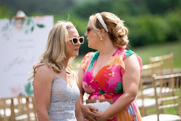 Two women both wearing sunglasses outside on grass