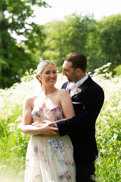 Bride and groom embrace hug in garden park