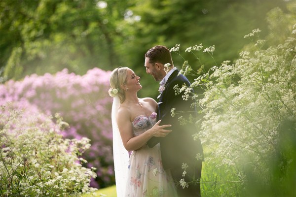 Bride and groom embrace hug in garden park