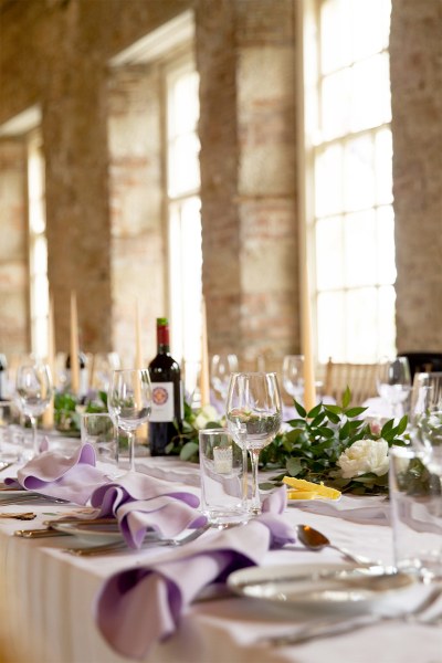 Empty dining room interior ballroom for guests candles and glasses on tables window view bottle of red wine