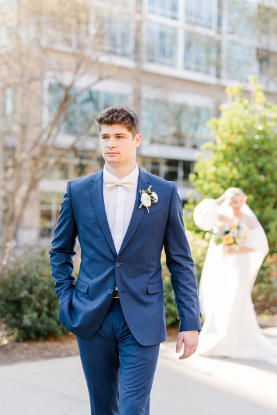 Bride and groom on the pathway to garden groom in focus