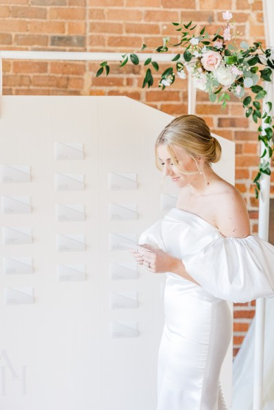 Bride looks down seating arrangement behind her