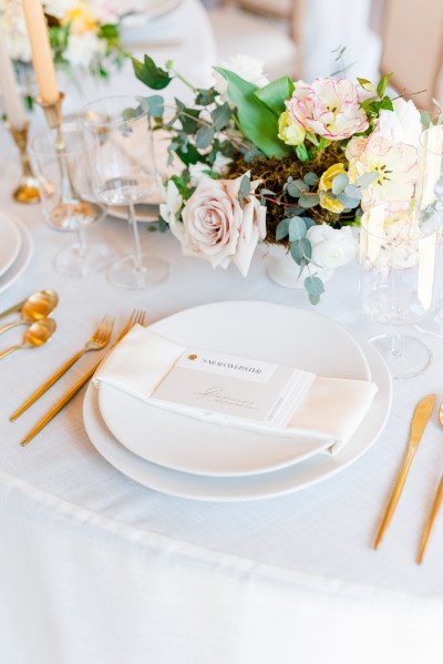 Table setting white pink roses flowers and candles gold theme forks and knives