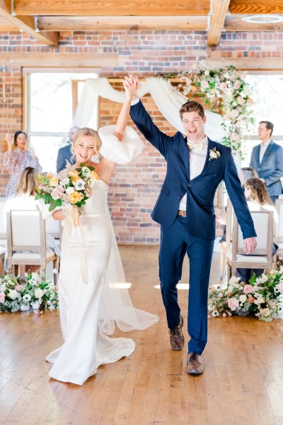 Hands in the air bride and groom after ceremony