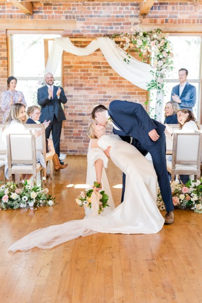 Groom bends bride over in dining room area