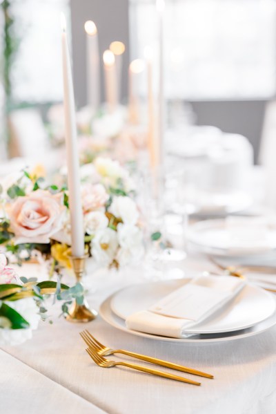 Table setting white pink roses flowers and candles serviette