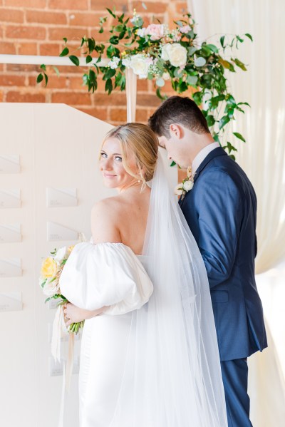 Bride looks over her shoulder groom looks down