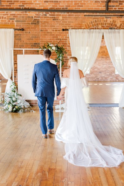 Bride and groom from behind veil detail long veil dress