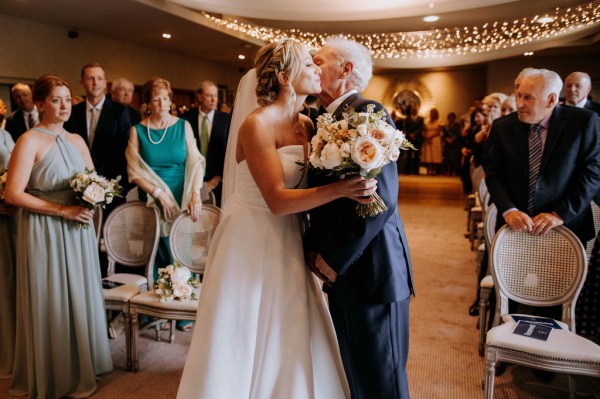 Bride kisses father on the cheek