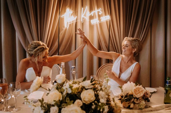 Brides cup hands at the dining room table