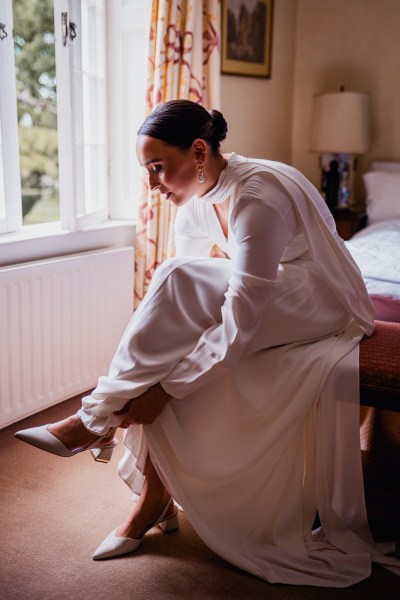 Bride putting on bridal heels shoes