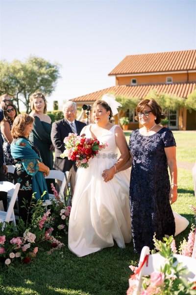 Mother and daughter bride walk down the aisle