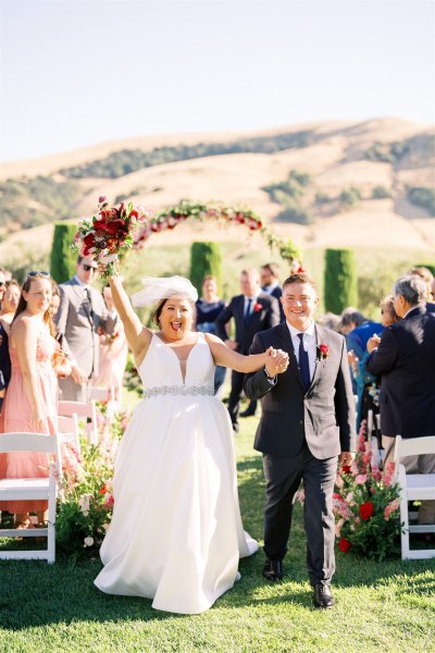 Bride and groom exit ceremony bouquet in the air