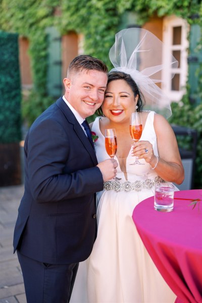 Bride and groom holding cocktail smiling