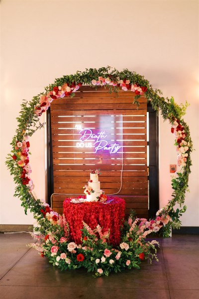 Cake surrounded by bed of flowers roses party sign