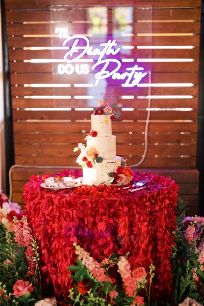 Cake surrounded by bed of flowers roses party sign