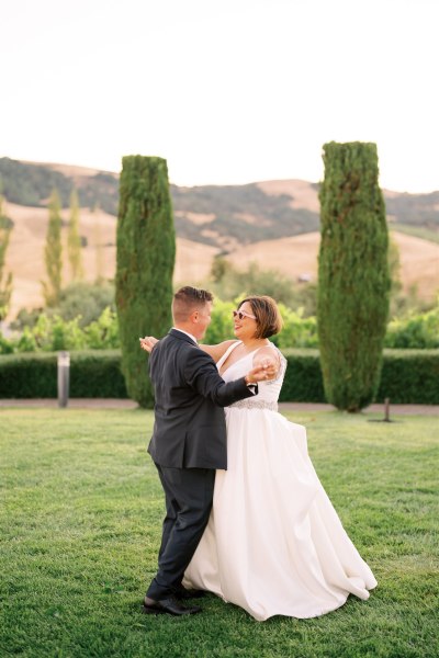 Bride and groom dancing on the grass