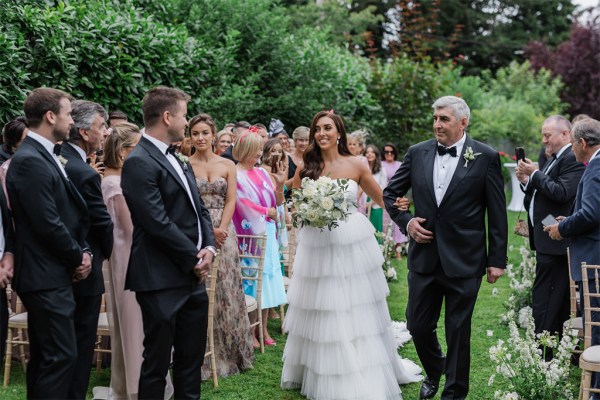 father of the bride hugs groom as he hands his daughter over