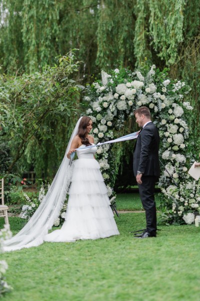 bride and groom are bound by ribbon at the top of the alter