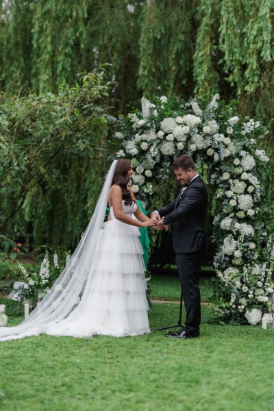 bride and groom hold hands at the top of the alter