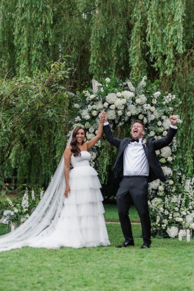 bride and groom celebrate at top of ceremony alter in front of guests