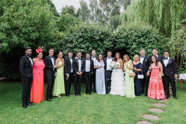 family portrait pic of bride groom mother and father standing on grass