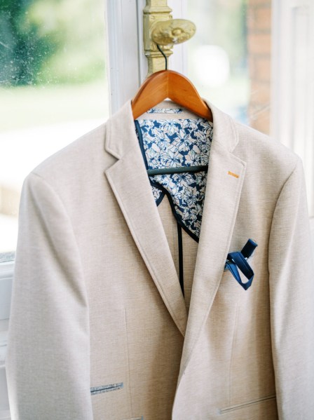 Grooms suit jacket hanging by window