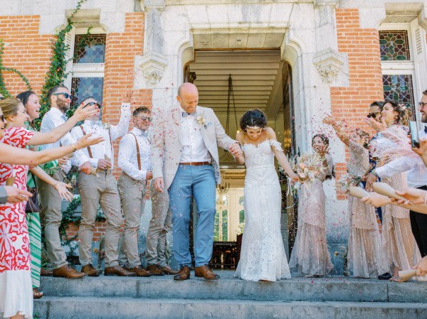 Bride and groom exit wedding venue guests clapping