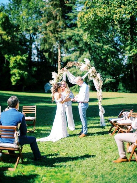 bride and groom with celebrant at top of alter setting