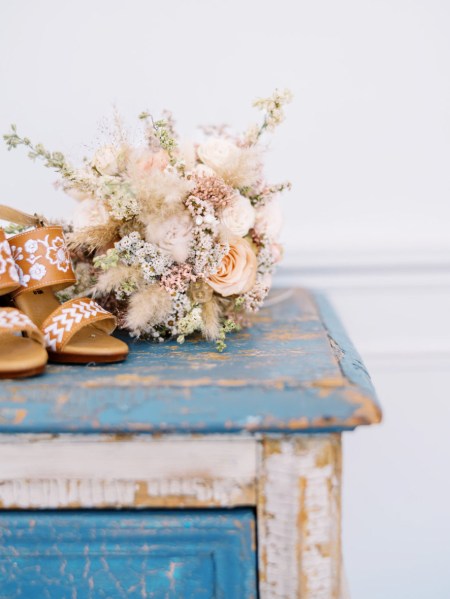 Flowers bouquet resting on blue painted wooden desk paint is chipped