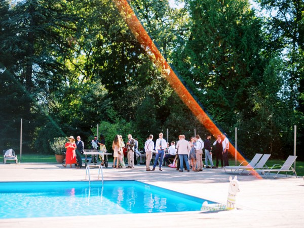 Wide shot view of blue pool and trees atmosphere shot of guests