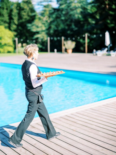 Pool view and waiter serving finger food