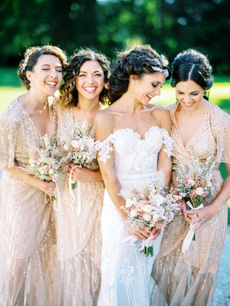 bride and her bridesmaids hold bouquets and pose for the camera