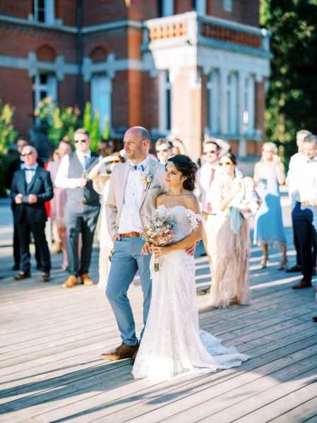 bride and groom outside surrounded by guests in courtyard