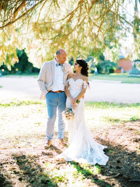 bride and groom stand in garden forest setting