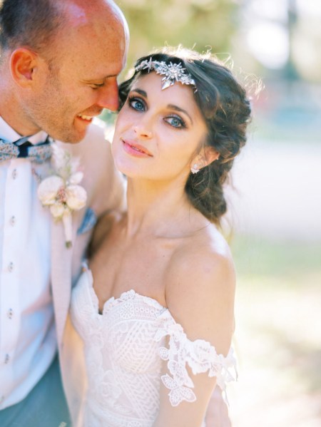 Bride and groom pose in garden forest setting