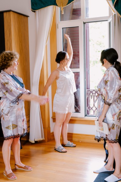 bride and bridesmaids she's waving to someone out of window