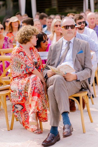 man and woman sit in the audience to ceremony