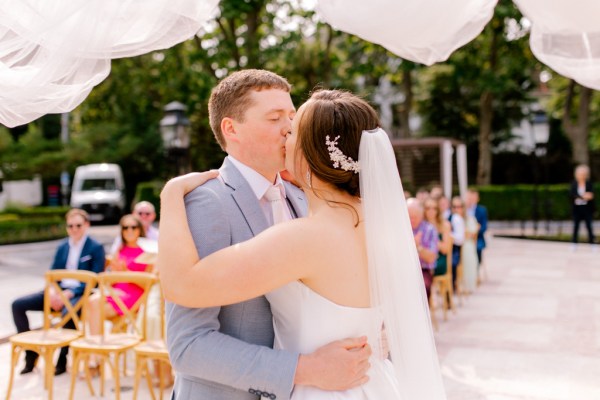 bride and groom share a kiss at the alter