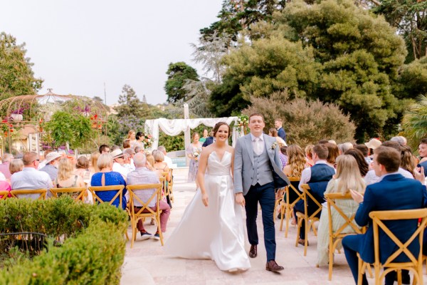 bride and groom exit ceremony with guests clapping