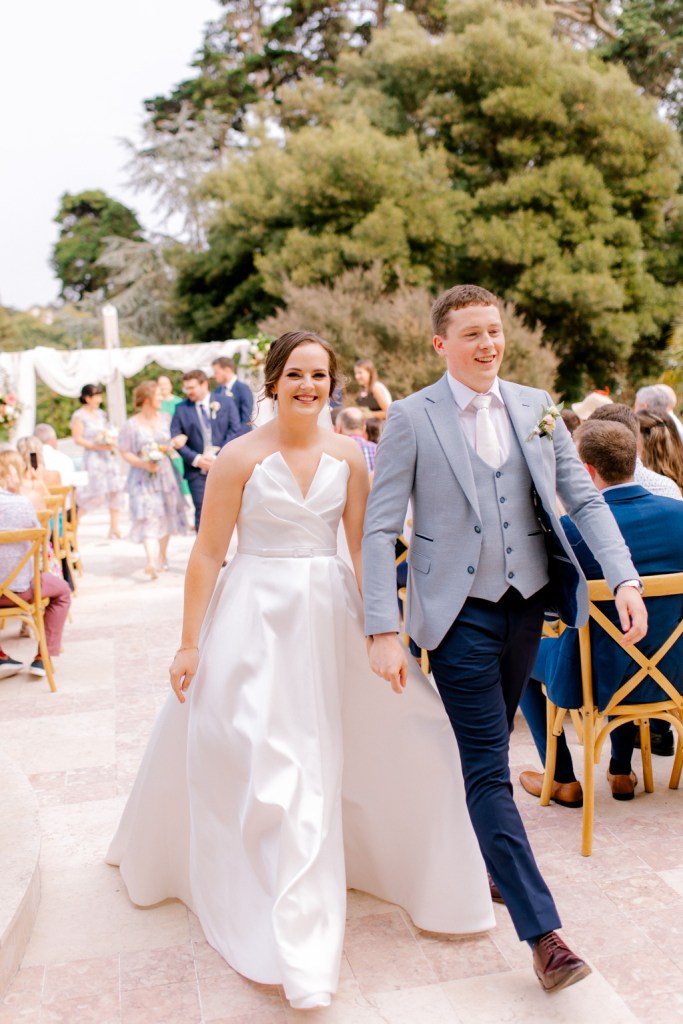 bride and groom exit ceremony with guests clapping